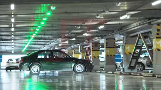 ระบบที่จอดรถอัจฉริยะ Parking Guidance System แสดงแถวไฟ LED สีเขียวเหนือช่องจอดที่ว่างในอาคารจอดรถ